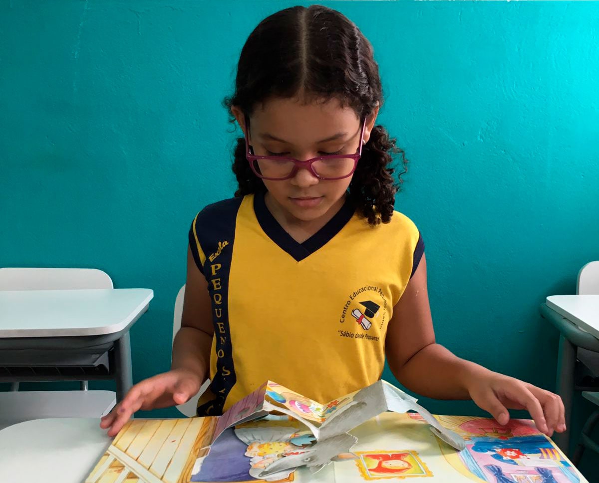 Aluna lendo na Escola Pequeno Sábio